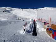 Transportband van de skischool bij het bergstation van de gondelbaan