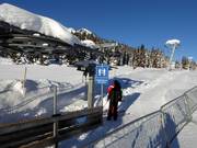 De beugel wordt bij het instappen in de sleeplift aangereikt.