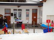 Skischoolkantoor en verzamelplaats bij het dalstation