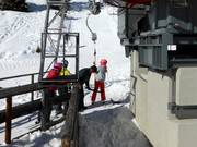 Personeel reikt de beugel aan bij de sleeplift