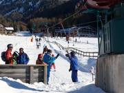 Het personeel helpt de skiërs bij de pannenkoeklift